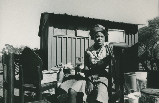 Women sits amongst her possessions after removal to Pachsdraai. 1984. Photographer: Paul Weinberg. AL2547_20.1.9