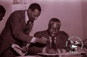 Joshua Nkomo and Amos Ngwenya signing the oath agreement in Lusaka, Zambia