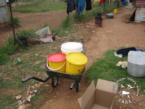 Three buckets carrying water loaded in a wheelburrow